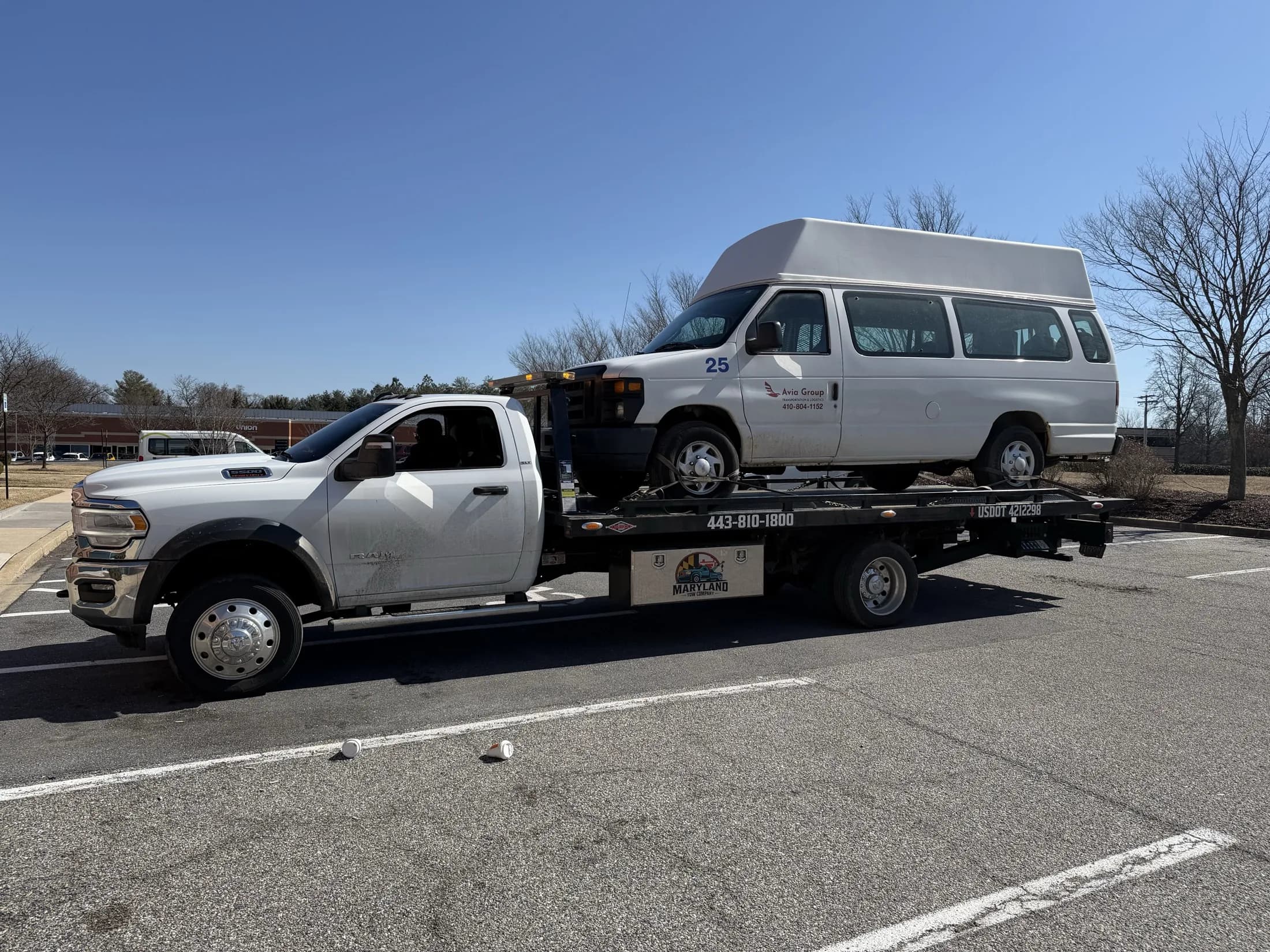Maryland Tow Company flatbed towing a passenger van